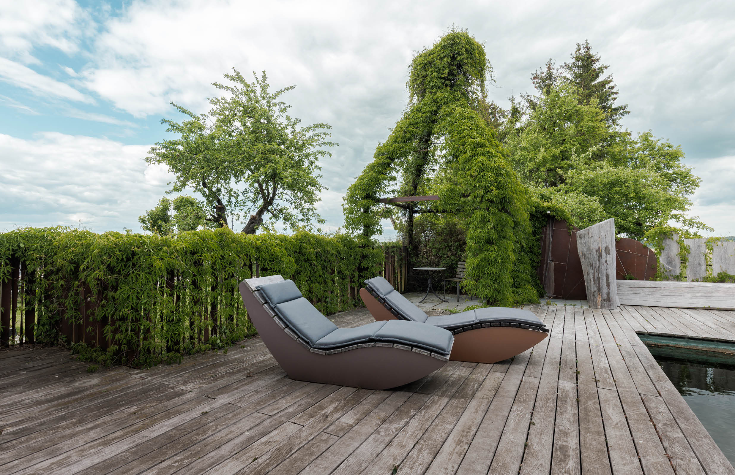 Relax-Liegen aus lackiertem Aluminium, Tisch aus Bronze mit geschmiedetem Fuß, Gartendusche aus Cortenstahl